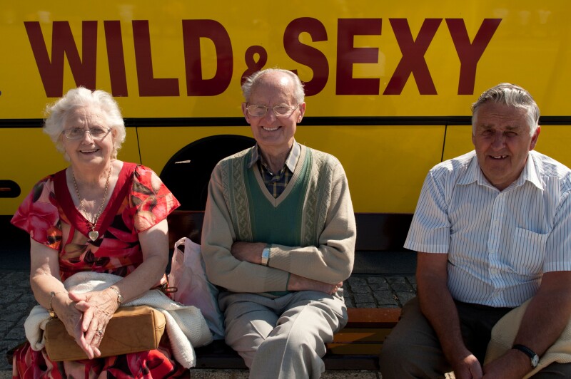 Wild and Sexy old age pensioners UK - ironic funny writing on bus behind them