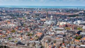 Aerial cityscape of The Hague (Den Haag) with the North Sea and cloudy blue sky, Netherlands