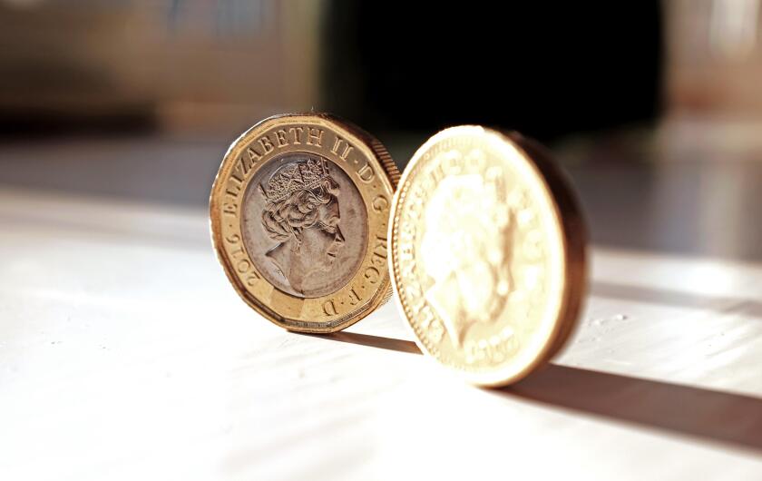 The new pound coin (left) and old pound coin British money sterling