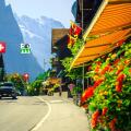 Picturesque cozy alpine village with shops and rustic wooden houses. Cute mountain village with flowery street and high mountains in background, Laute