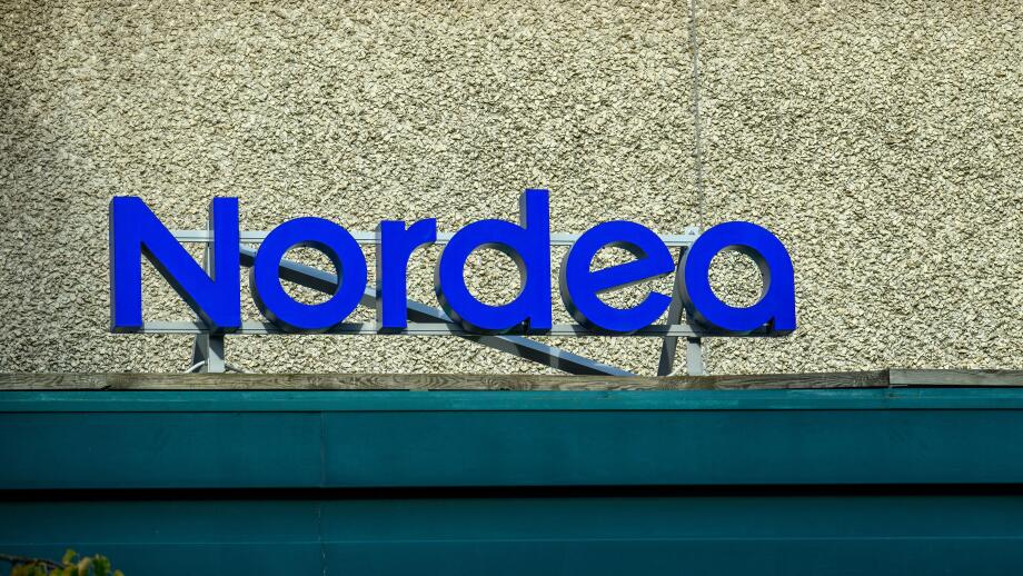 A prominent blue sign displays the name of the bank, Nordea, on the exterior of a well-maintained building, emphasizing its modern design and accessib