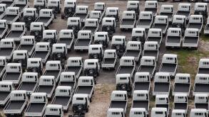 An aerial view of industrial light vehicles parked neatly in an open space.