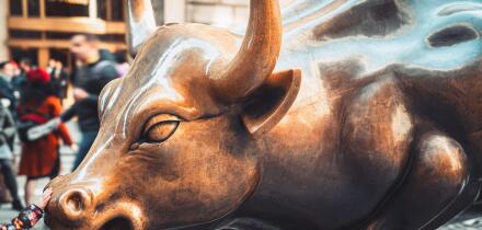 Wall Street charging bull statue in New York City with people