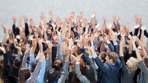 Crowd of business people cheering with arms raised