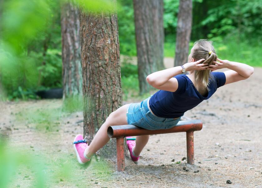 Woman doing abs workout in the forest.