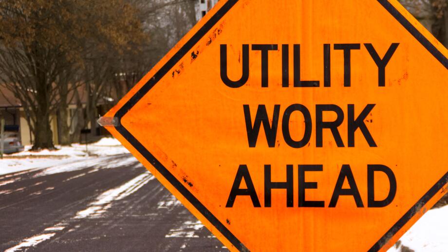 Utility work ahead road construction warning sign.