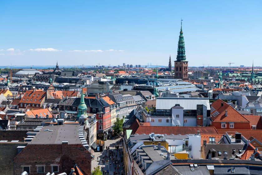 View over city from Rundetaarn (Round Tower) looking towards spire of the Nikolaj Contemporary Art Center (St Nicholas Church), Copenhagen, Denmark