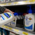 Woman taking Cetaphil gentle skin cleanser inside Walmart store