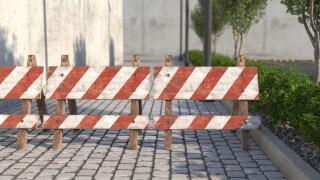 Old wooden road barrier on the sidewalk closeup. Warning sign about the closure of the passage on the road. 3D render.