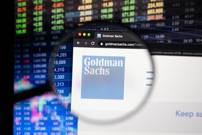 Goldman Sachs company logo on a website with blurry stock market