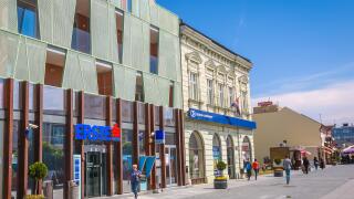 VUKOVAR, CROATIA - MAY 14, 2018 : People walking in the city center in front of the Erste bank building in Vukovar, Croatia.
