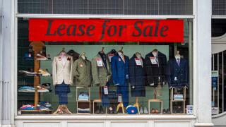 Lease for Sale banner sign in the window of a tailors shop in London.