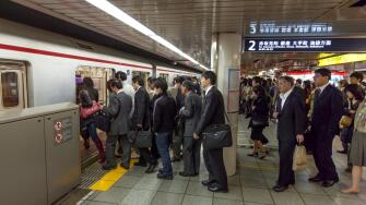Japanese commuters boarding underground train in Tokyo, Japan