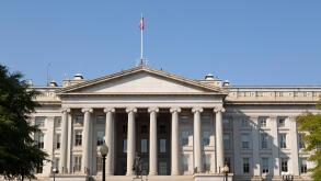 The Treasury Building in Washington DC, USA. A statue of Alexander Hamilton stands outside of the Neo-classical Treasury Building.