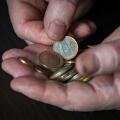 Old male hand holding euro coins, close up. Hands hold euro coins of different denominations. Inflation, purchasing power and social crisis