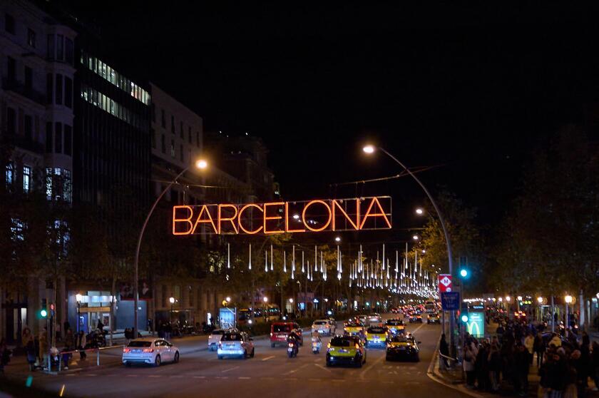 Barcelona. Spain - January 14, 2026: Night traffic on an iconic Barcelona street with taxis and decorative city lights.