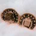 Two copper penny coins in close up wrapped in cotton wool for protection. Protecting money and austerity concept. UK