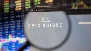 Epic Suisse company logo on a website with blurry stock market developments in the background, seen on a computer screen through a magnifying glass