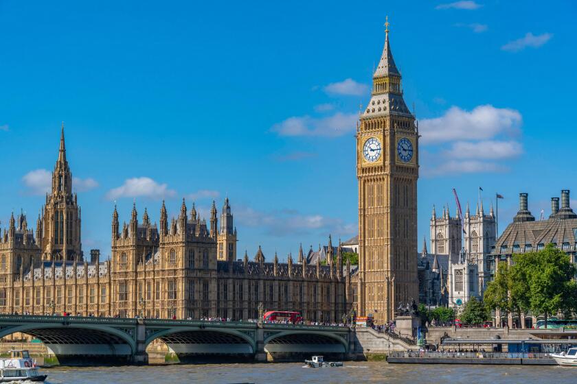 View of Houses of Parliament and Westminster Bridge from Queens Walk during summer in Westminster London England