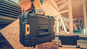 Closeup of Toolbox with Professional Carpentry Tools and Equipment in a Hand of Contractor Entering the Building Site to Start His Work. Industrial Th