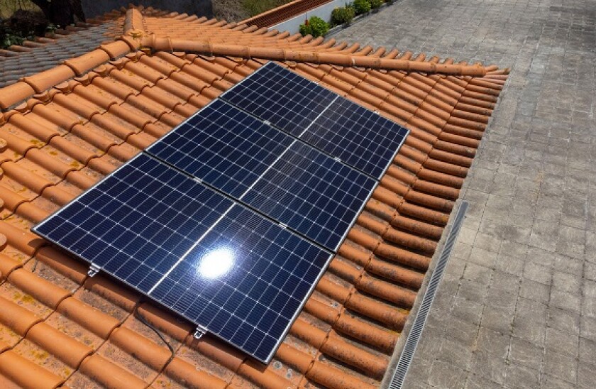 Three photovoltaic solar panels on the roof of a house