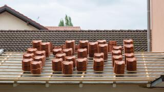 Stacks of roof tiles on a roof under construction. Symbol for roofer as a profession or the building construction