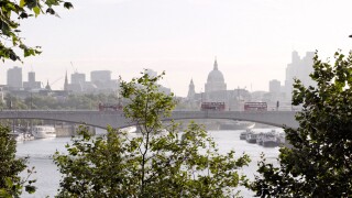 London, UK. Waterloo Bridge, St Paul's Cathedral, River Thames and London Skyline with green trees and red buses