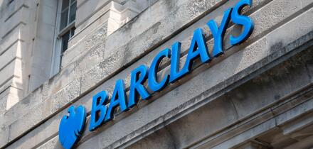 Large sign outside a branch of Barclays Bank in a city, UK.
