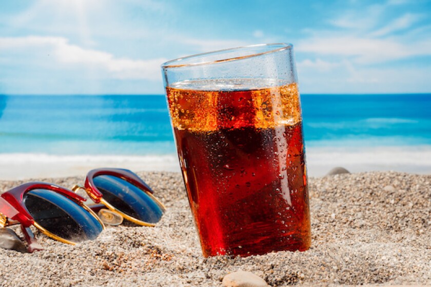 A cold drink in a glass on the beach, a delicious soft drink in the summer