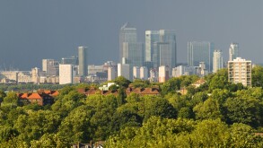 Green London, looking towards Canary Wharf in distance, City of London skyline from south east suburban London, homes, blocks of flats trees in foreground. 2010 2010s UK HOMER SYKES