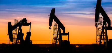 Silhouette of Oil pumps at oil field with nice sunset sky background