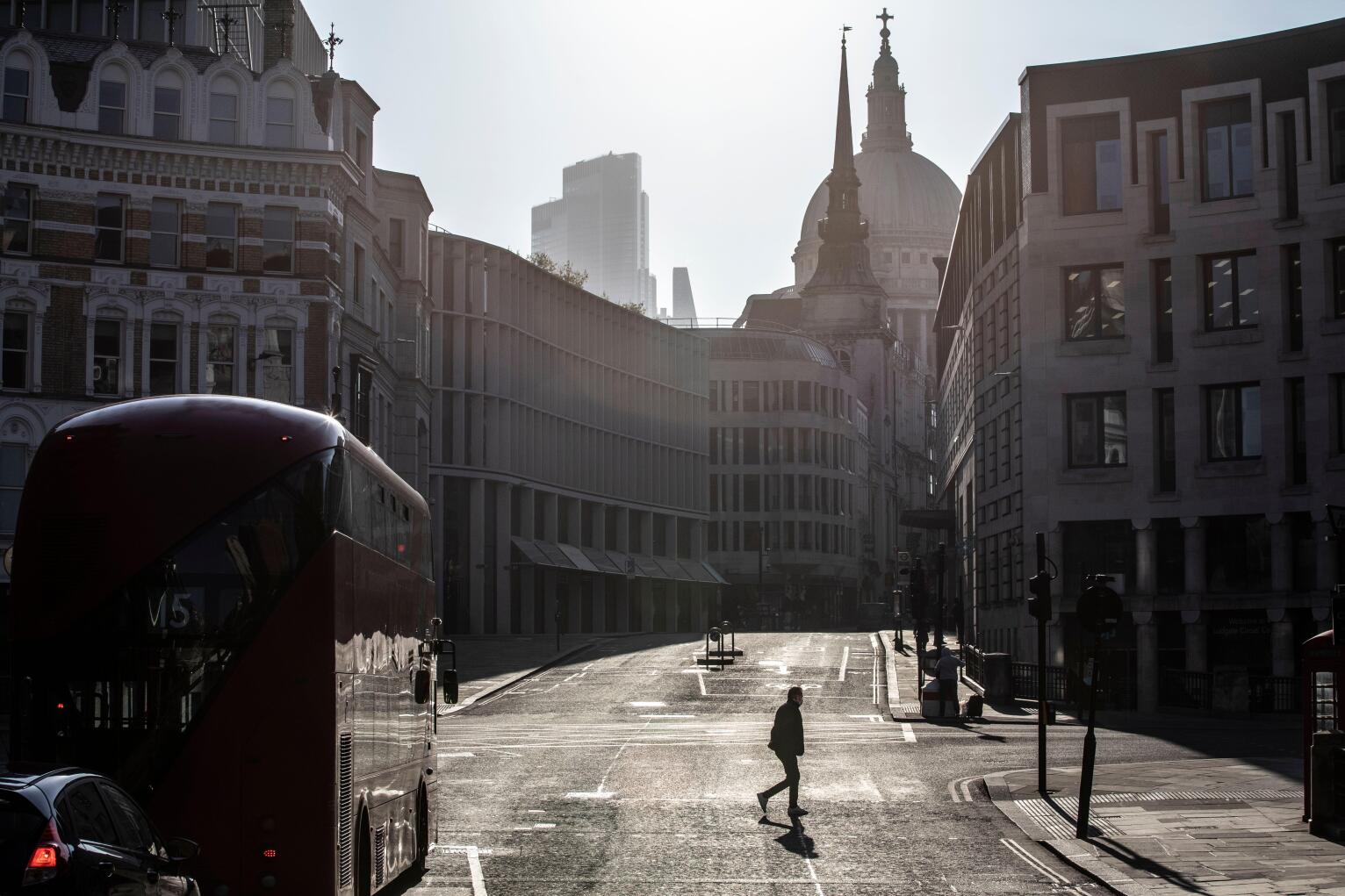 London, UK. 23rd Apr 2020. A lone commuter walks across Ludgate Circus early this morning in the City of London, as lockdown measures need to be eased out in the next three to four weeks amid coronavirus for the economy to recover. City of London lockdown