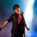 Rock lead singer on stage wearing a hat and sunglasses