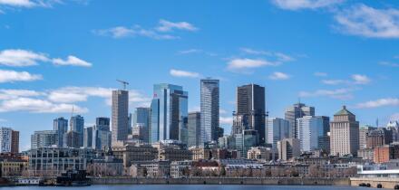 Montreal, Canada - April 4, 2025: A scenic view of Montreal's skyline from the St. Lawrence River, featuring urban architecture against a bright sky