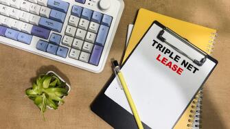 Concept of Triple Net Lease write on paperwork isolated on Wooden Table.
