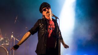 Rock lead singer on stage wearing a hat and sunglasses