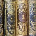 Vintage ornate book spines with intricate gold designs and numbers.