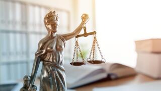 Lady Justice statue in law firm attorney office, blindfolded Justitia with balance scales and sword is personification of moral force in judicial syst