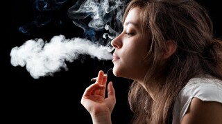 Woman Smoking a Cigarette on Black Background