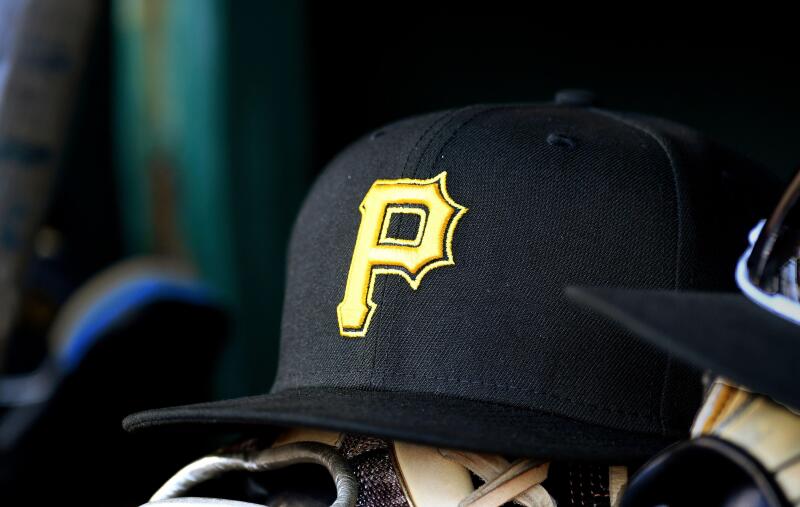 WASHINGTON, DC - APRIL 29: A New Era Pirates baseball hat cap with the yellow P Pirates logo sits on a baseball glove on the dugout bench during the Pittsburgh Pirates versus Washington Nationals MLB game 2 at Nationals Park on April 29, 2023 in Washingto