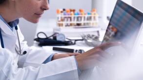 Doctor accessing a patients details using a touch screen computer in the clinic