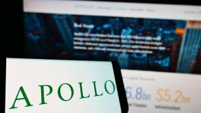 Smartphone with logo of US investment company Apollo Global Management Inc. on screen in front of website. Focus on center-left of phone display.