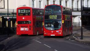 Two double decker buses passing in North London on a sunny day London England UK