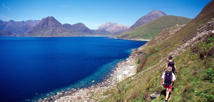 Walkers heading towards the Black Cuillin on the coastal path from Elgol, Isle of Skye, Scotland