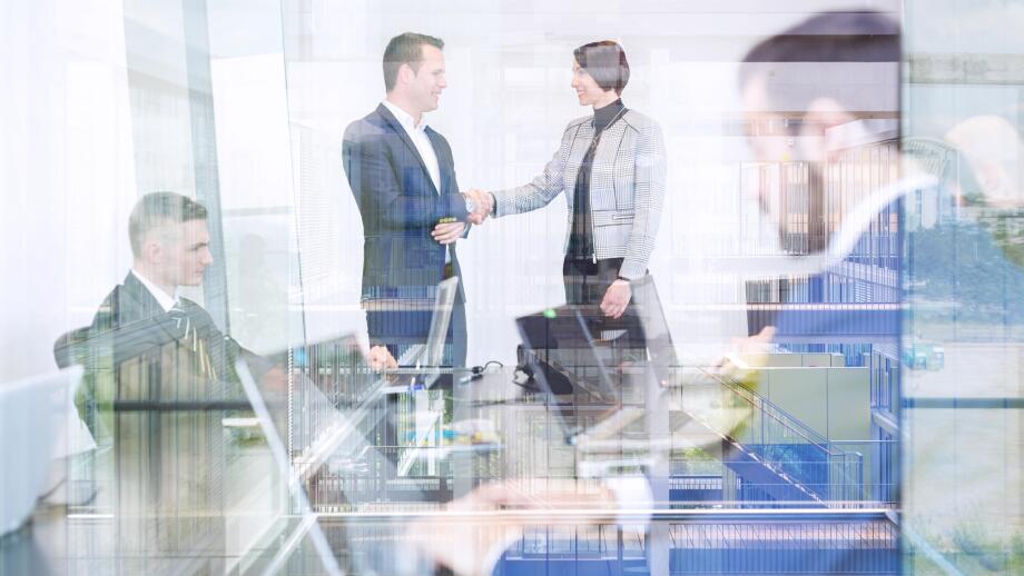Business people shaking hands in moder corporate office.
