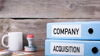 Company and Acquisition. Two binders on desk in the office. Business background