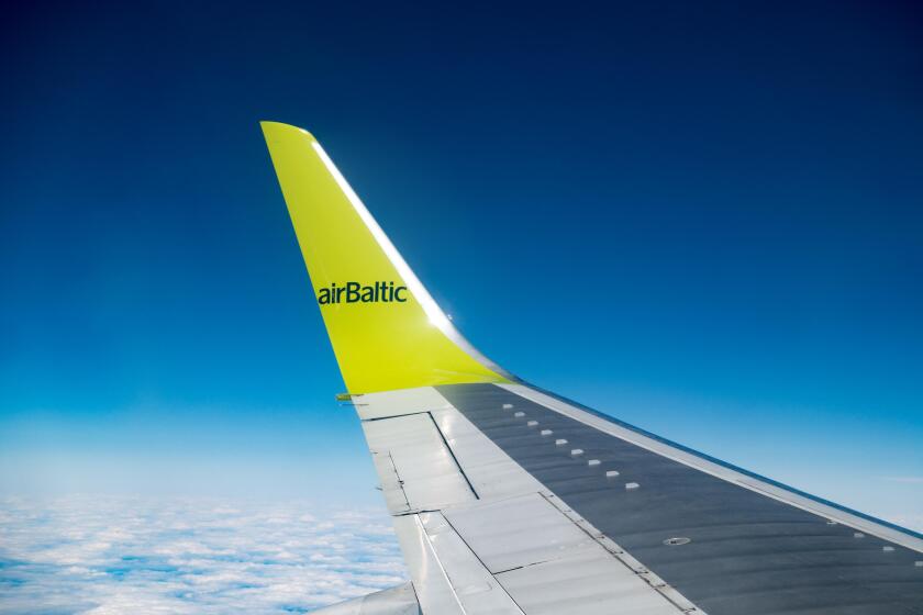 RIGA, LATVIA - MAY, 25, 2016: Aircraft wing,  Clouds skies above and below. AS Air Baltic Corporation,  is the Latvian flag carr