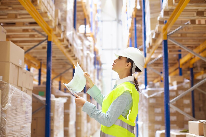 Female warehouse worker checking stock