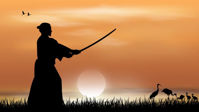 Samurai stands with a sword in his hands against the backdrop of a sunny sunset. Japanese landscape.