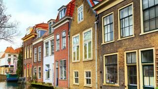 street view with traditional dutch houses, canal in downtown of popular Holland destination Delft, Netherlands